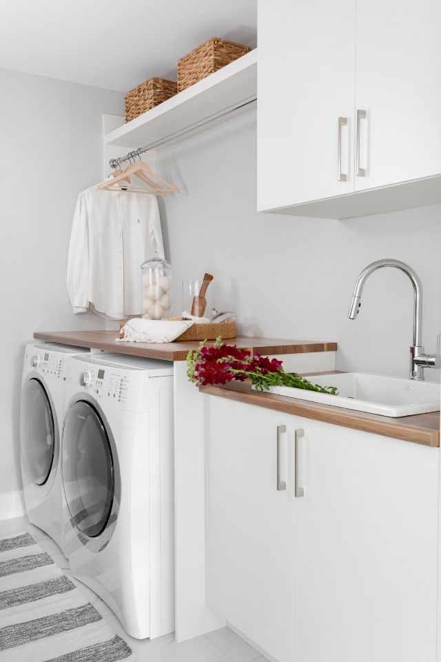 White cabinets and gray walls in laundry room with new washer and dryer